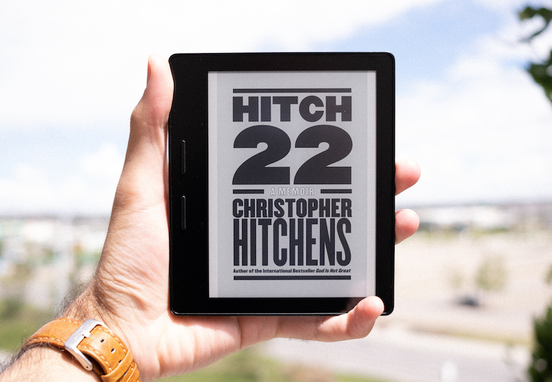 A picture of a Kindle with the book cover of 'Hitch-22' on display.