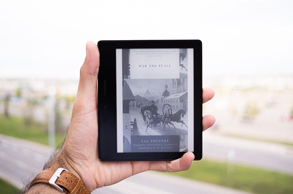 A picture of a Kindle with the book cover of 'War and Peace' on display.
