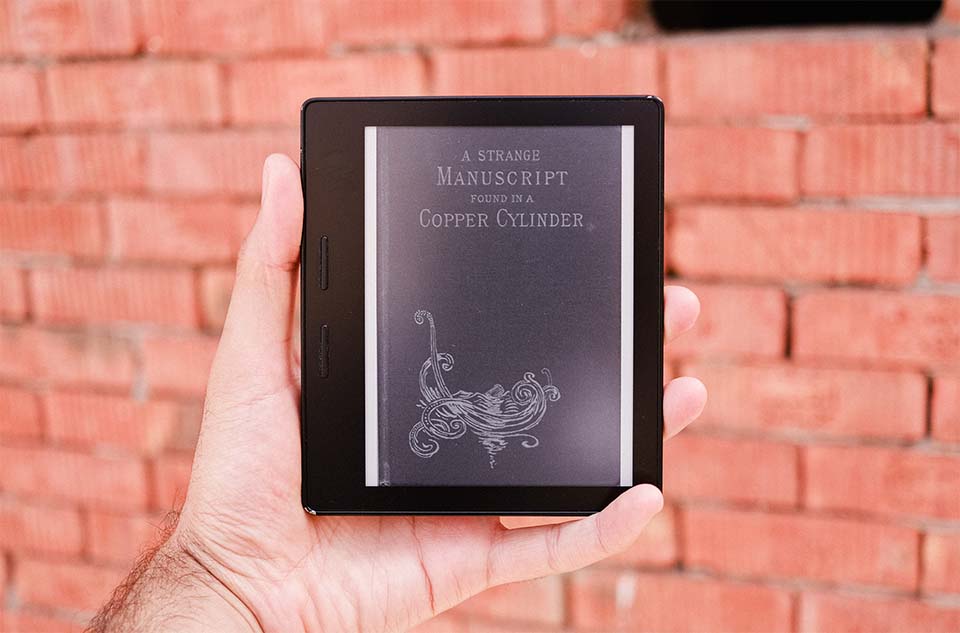 A picture of a Kindle with the book cover of 'A Strange Manuscript Found in a Copper Cylinder' on display.