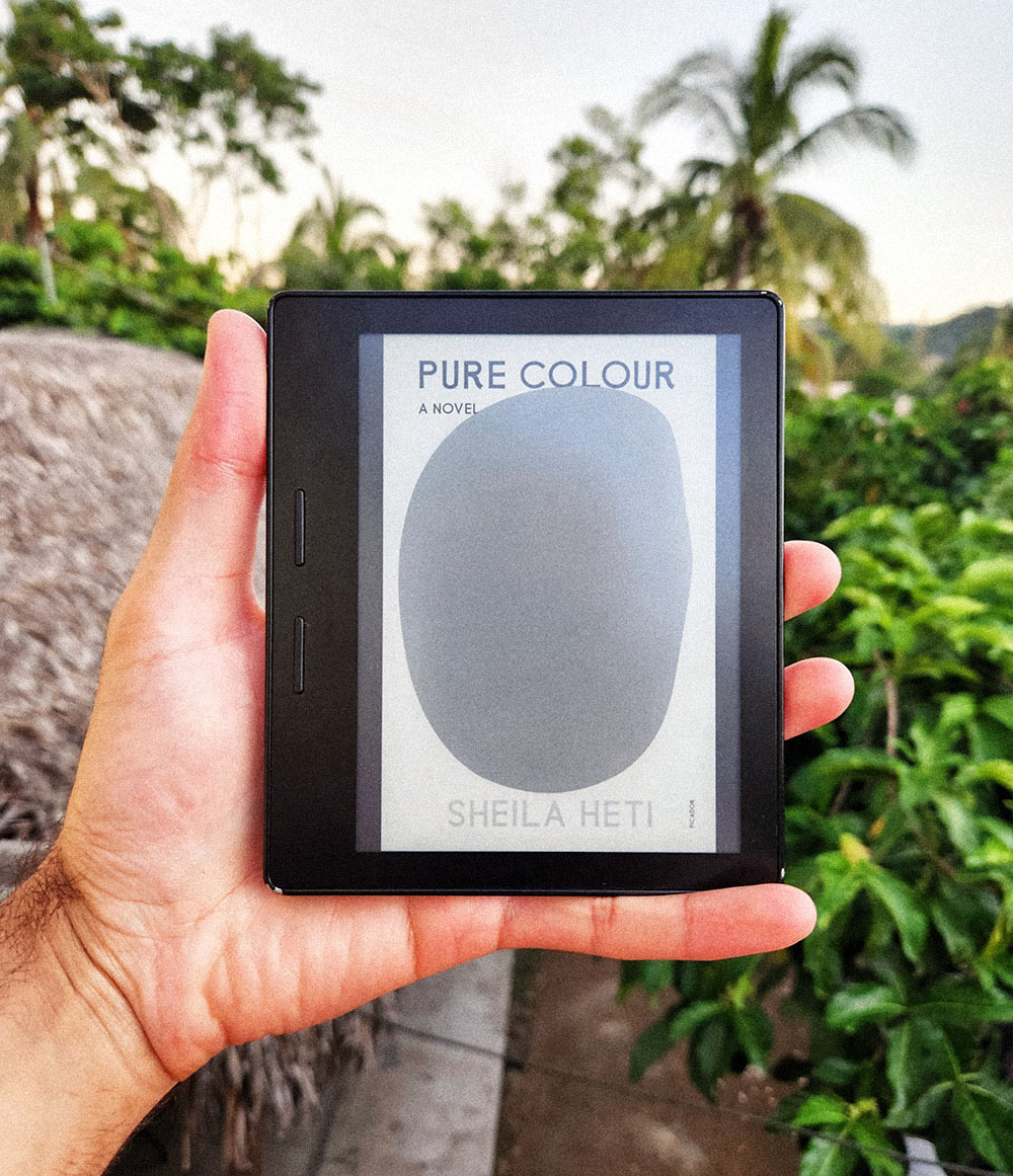 A picture of a Kindle with the book cover of 'Pure Colour by Sheila Heti' on display.